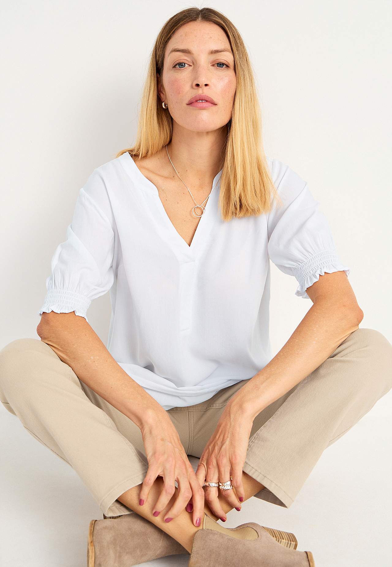 Tunic with smocking on the sleeve ends